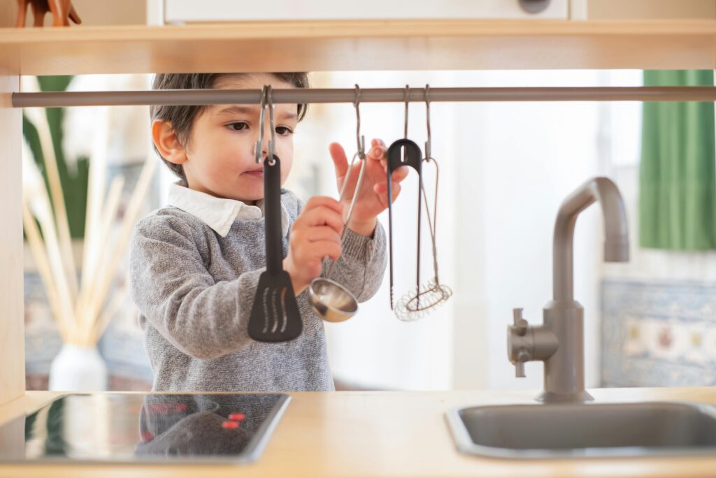 A young child having fun exploring kitchen utensils in a cozy indoor setting.